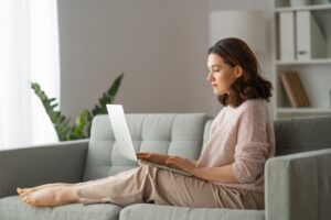Junge Frau arbeitet konzentriert am Laptop von zuhause. Symbolbild für Online-Coaching und Selbstcoaching